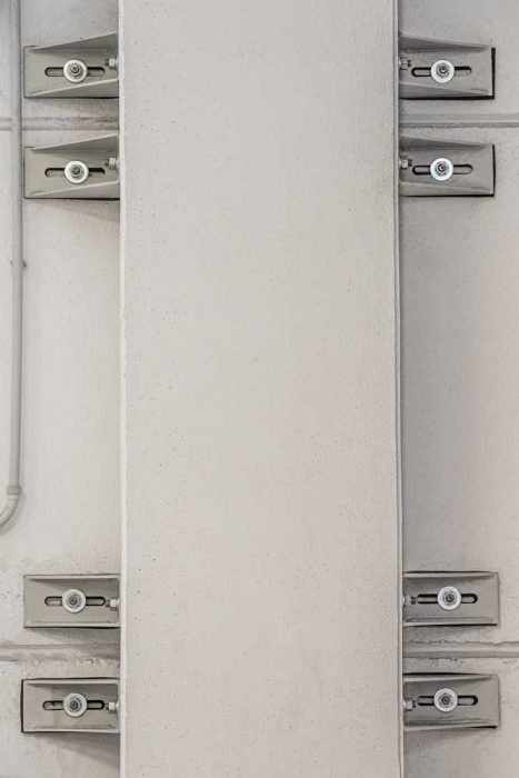 pilastro tramite profilo angolare con asola orizzontale per consentirne lo scorrimento.